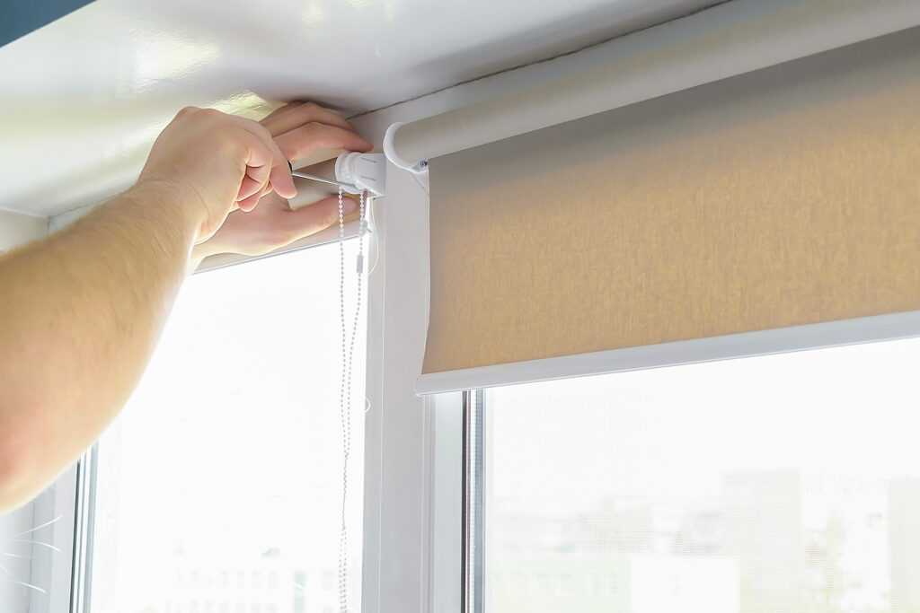 Man,Worker,Installing,Attache,Mounting,Bracket,On,Roller,Blinds,shades,on,Window